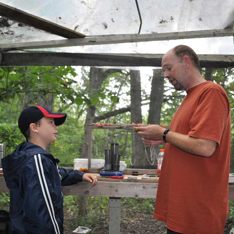 Field Coordinator Graeme Gibson the younger (right) instructs a young birder on the finer points of banding.